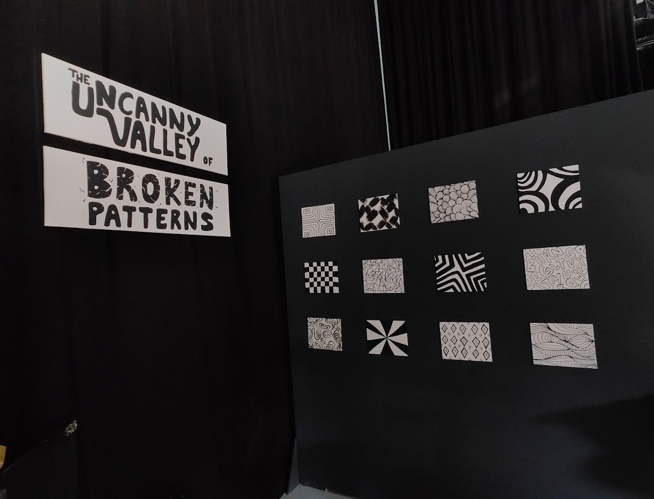 Entrance display of The Uncanny Valley of Broken Patterns exhibit, showing patterned tiles on a black panel